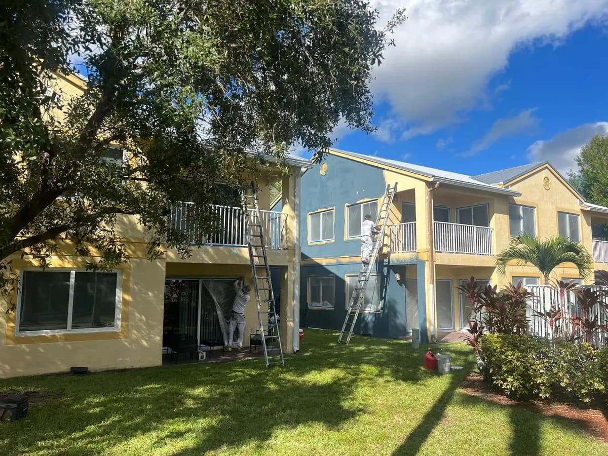 Smart Coat painters on ladders repainting a two-story condominium building