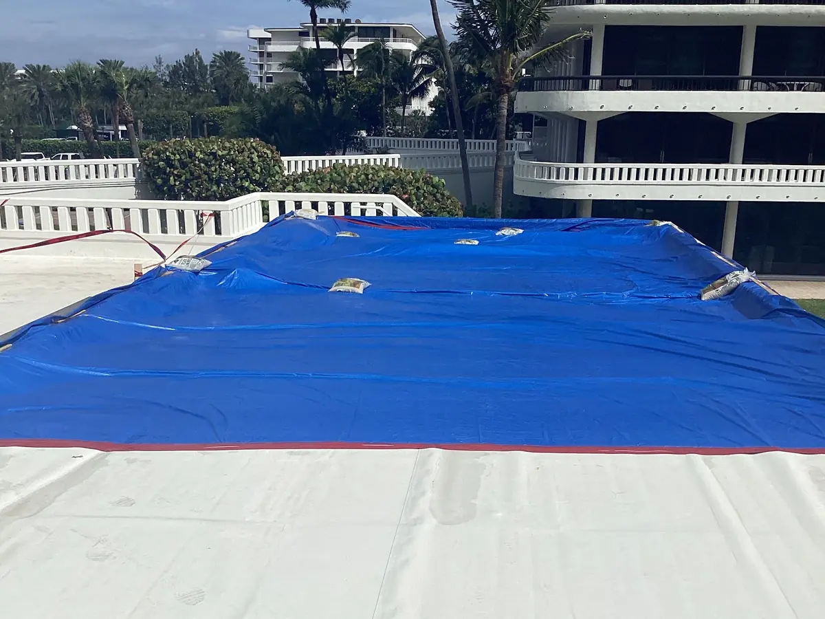 Restored deck finished white, a blue tarp protecting the next section