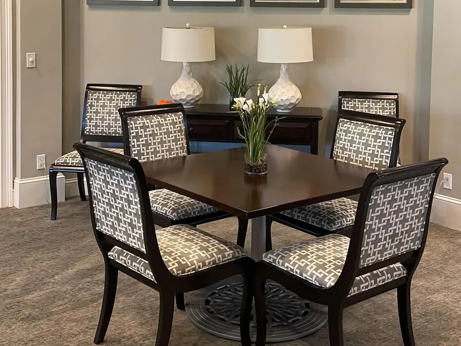 Clubhouse dining room after interior painting: greige walls, white crown molding and a dark wood table