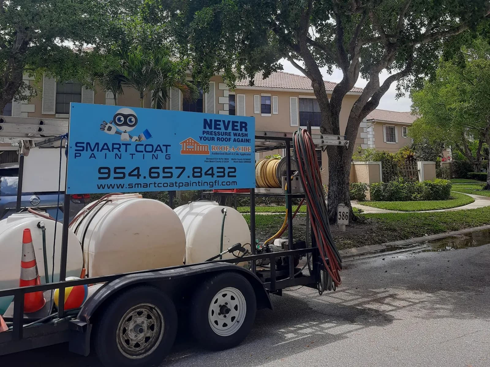 Smart Coat pressure-washing trailer with water tanks parked outside a townhome community