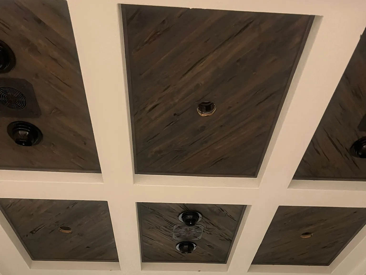 Coffered ceiling with dark wood panels between white beams in a remodeled Jupiter home