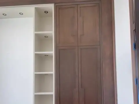 Stained wood built-in cabinets beside white shelving in a home office