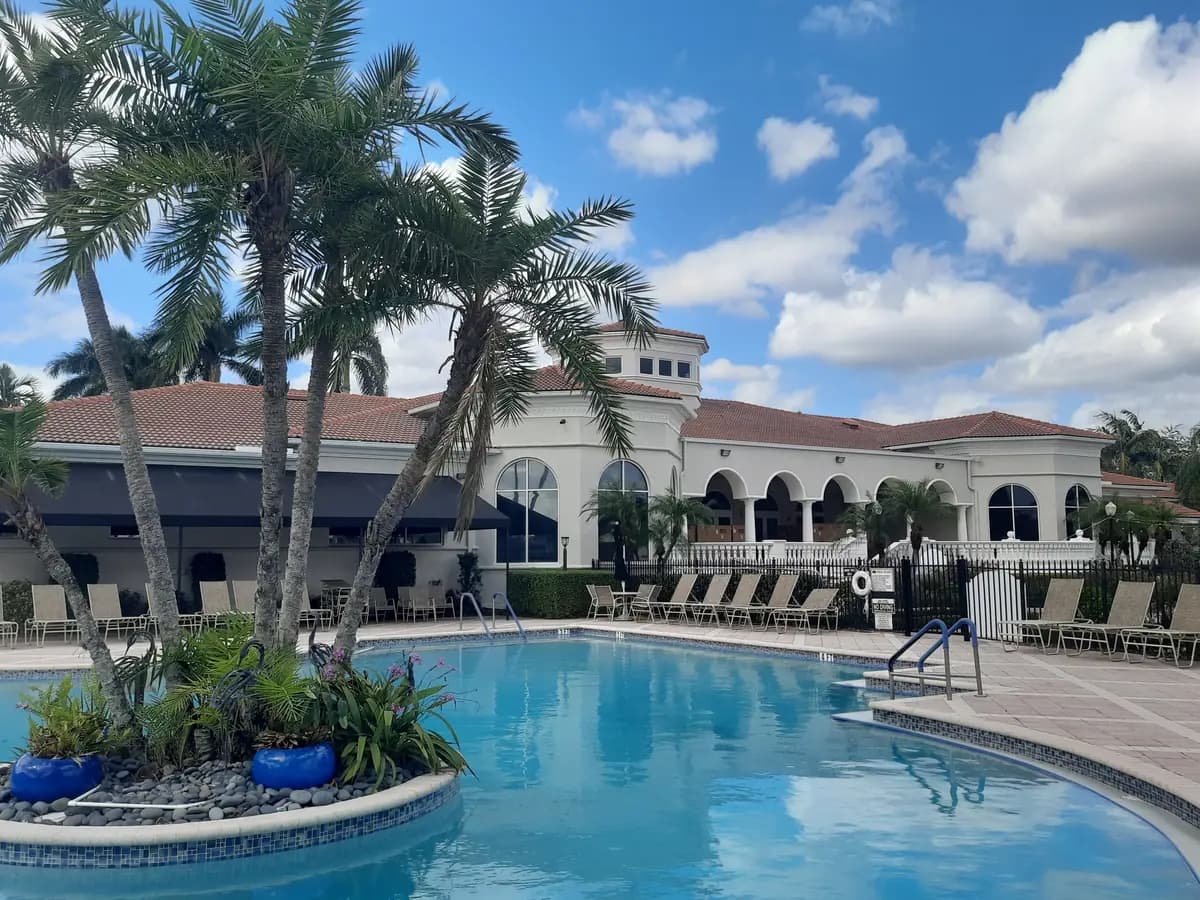 Clubhouse pool deck and white arcade under a clean terracotta tile roof