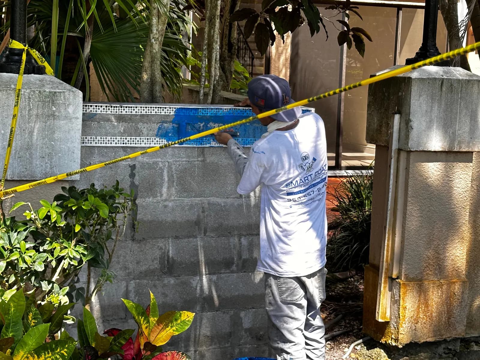 Smart Coat mason rebuilding a concrete block perimeter wall before stucco