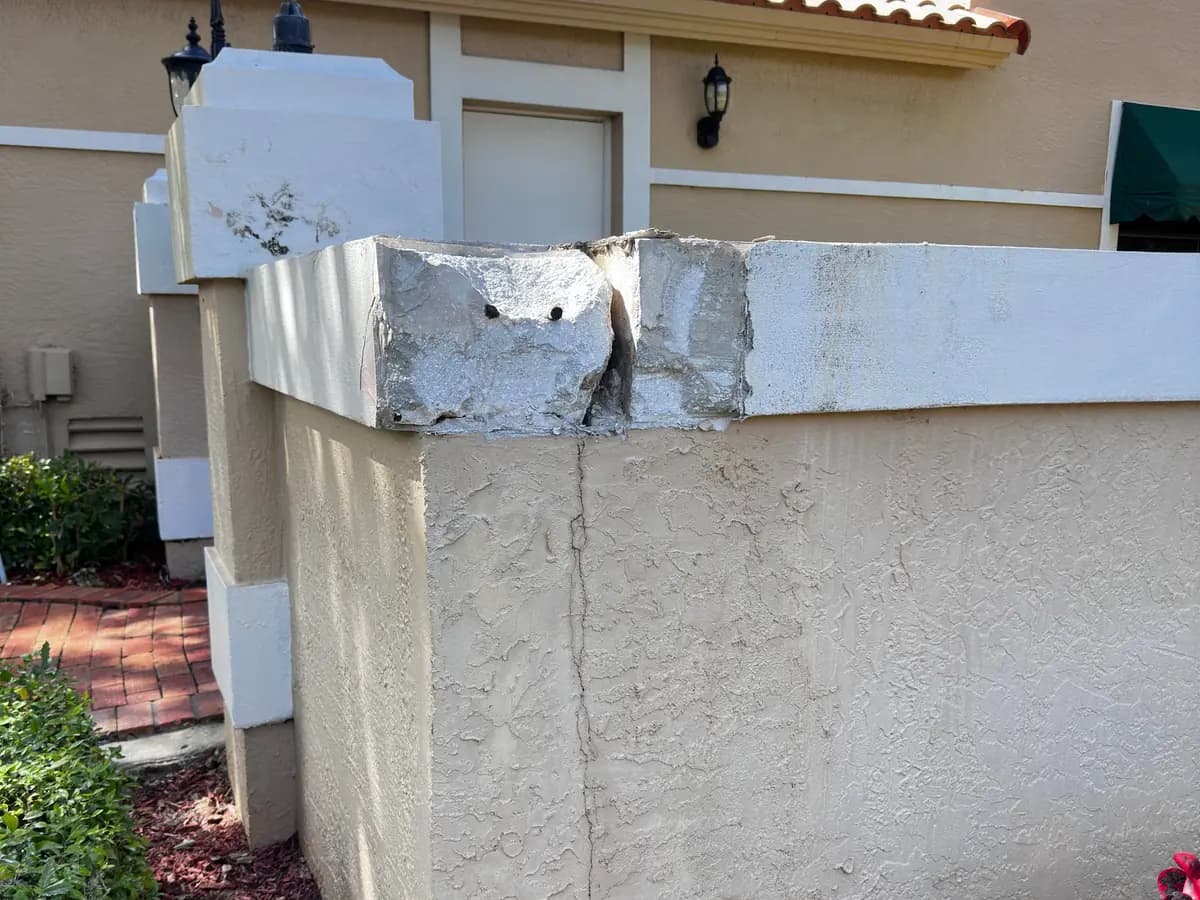 Stucco wall cap cracked open along its corner before repair
