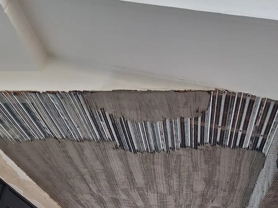 Soffit opened to rusted lath and spalled stucco before repair