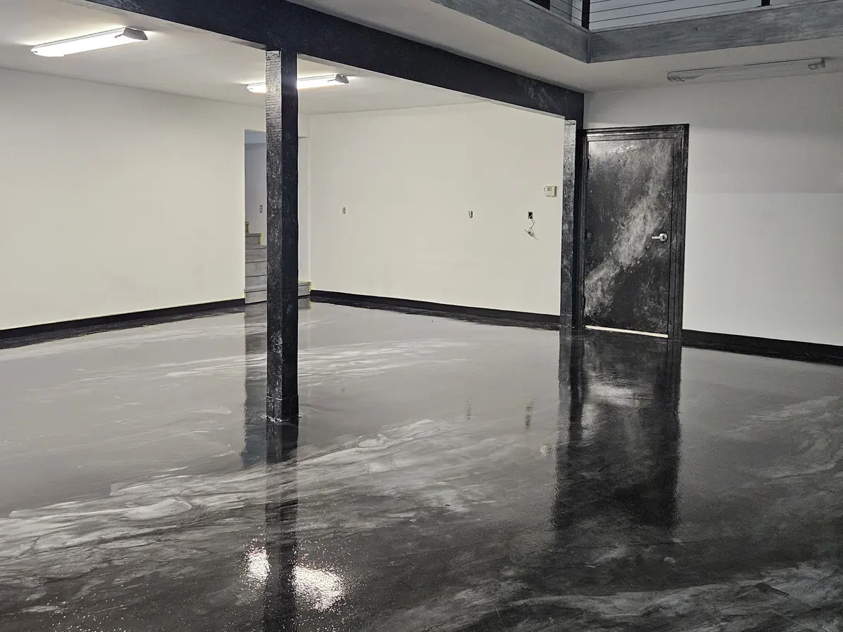 Finished glossy black metallic epoxy floor in a commercial space